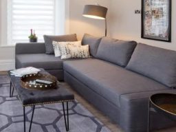 Modern bedroom featuring a large double bed with patterned headboard and stylish décor.