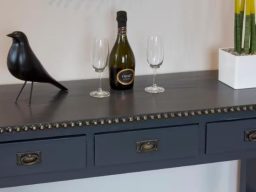 Blackbird Luxury Accommodation Suite 7 A wooden high table with four black stools, fruit on the table and a plant decoration.