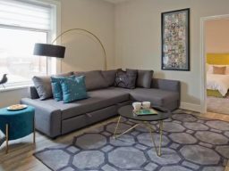 Blackbird Luxury Accommodation Suite 7 Brown leather sofa with decorative pillows and a lamp in a light-filled room.
