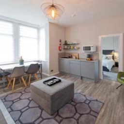 Blackbird Luxury Accommodation Suite 7 Neutral-toned bathroom with a oval mirror, modern sink, and shower area visible.