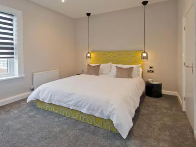 Blackbird Luxury Accommodation Suite 7 Neatly arranged bedroom with a double bed, patterned cushions, and bedside tables.