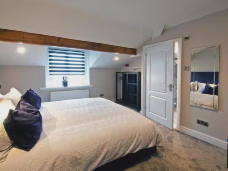 Blackbird Luxury Accommodation Suite 7 Neatly arranged bedroom with a double bed, patterned cushions, and bedside tables.
