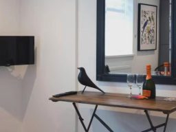 Blackbird Luxury Accommodation Suite 7 A wooden high table with four black stools, fruit on the table and a plant decoration.