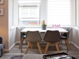 Blackbird Luxury Accommodation Suite 7 A wooden high table with four black stools, fruit on the table and a plant decoration.